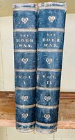 Front view of two leather bound volumes titled 'The Boer War Vol. I' and 'The Boer War Vol. II' showing some wear to the top edges and spine.