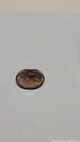 Oval cut smokey quartz gemstone showing faceted surface and deep cognac color from above angle.