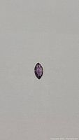 Photo of the marquise cut purple sapphire displaying its unique shape and color.