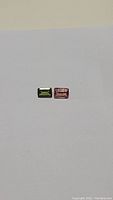 Photo showing untreated forest green and bubblegum pink emerald cut tourmaline gemstones on a white background.