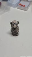 Front view of natural carved dog figurine showing stone patterns and carving details.
