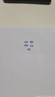 Five oval cut natural tanzanite gemstones arranged on a white surface.