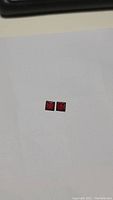 Pair of square cut red Almandine garnet gemstones on white background showing size and color