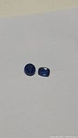 Two natural royal blue kyanite gemstones shown on white background for color and clarity assessment.