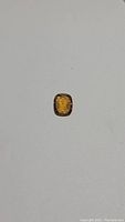 Top down photo of the natural whiskey colored citrine gemstone on white background showcasing its deep amber hue and cushion cut shape.