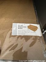 Close-up photo of a label on the box showing dimensions and an illustration of a flat packed box.