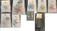 Photo showing multiple packaged earring sets in various colors and styles including beaded hoops and dangling styles.
