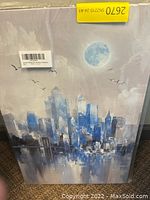 Photo of 27 x 16 canvas print depicting an abstract blue cityscape with moon and birds.
