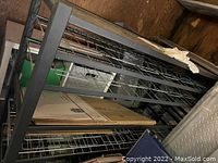 Metal shelving unit with wire shelves, showing top and side angles and some items stored on it.
