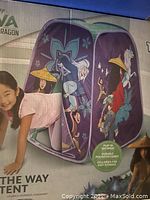 Photo of box showing a child crawling through the Raya and the Last Dragon themed kids pop up tent with colorful graphics