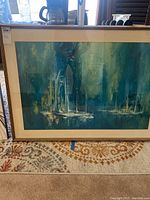 Front view of framed wall art print showing sailboats in harbor during evening with glass and light frame.