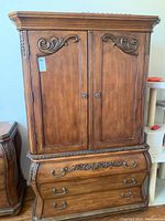 Front view of two-piece solid wood TV cabinet with carved details on doors and drawers