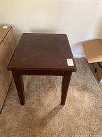 Top down view of dark wood end table showing patterned surface and square shape