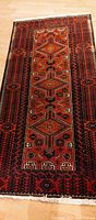 Full-length view of the rectangular rug showing overall geometric design, fringe, and color palette.