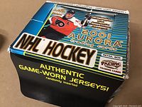 Full retail box front showing 2001 Aurora NHL Hockey trading cards branding, player image, and feature highlights such as authentic game-worn jerseys and autographs.