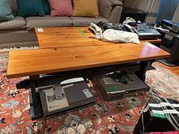 Two-tone wooden bench showing natural wood top and dark painted base in a living room setting.