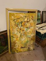 Full view of painting leaning against wall with frame visible behind