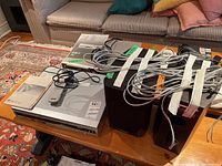 Overview of Sony DVD recorder, Dual receiver/cassette unit, Mission speakers and assortment of cables on coffee table