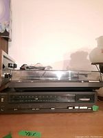 Front view showing turntable with dust cover over stereo receiver below