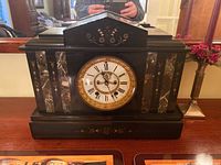 Full front view of black stone Seth Thomas mantle clock on wood surface