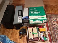 Photo showing two accordion style file cases side by side with boxes of Permax file folders and assorted office supplies on top and nearby.