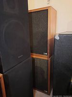 Two Pro Line AR 2 speakers stacked vertically showing wooden frames and black fabric front.