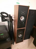 Two wood‐framed Harbeth speakers stacked vertically, side view.