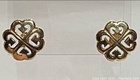 Front view of both clover-shaped studs on clear stand