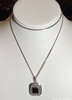 Front view of necklace with red crystal pendant on display bust