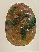 Front view of carved jade pendant showing detailed dragon design