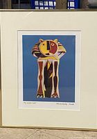Framed print showing the stylized Picasso Cat artwork with mat and frame, held upright.