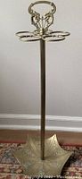 Full view of the brass umbrella stand showing umbrella-shaped base and five holders