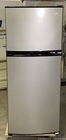 Front view of closed refrigerator, stainless steel front, black sides