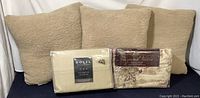Photo of three tan teddy faux fur pillows and two packaged bedding sets