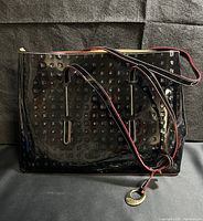 Front view of Arcadia black patent leather tote with embossed pattern and shoulder straps.