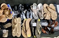 Top view of all eleven pairs of sandals displayed together showing variety of styles and colors