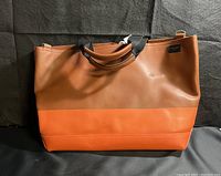 Front view of the two tone leather tote bag showing colors and handles
