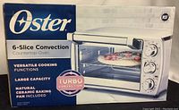 Front view of the original box showing Oster branding, 6-slice convection capacity, turbo convection technology, and ceramic baking pan inclusion.