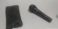 Photo of the Apex 870b microphone and the soft carrying case placed on a white surface