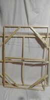 Two wooden canvas frames showing back sides with bracing and hanging wire.