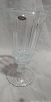 Side view of clear crystal candle holder showing vertical fluted design and pedestal base with octagonal shape.