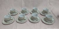 View of the complete set of 8 espresso cups with matching saucers arranged in two rows.