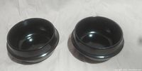 Top view showing the interior and round shape of the two black stone bowls side by side.