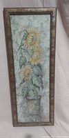 Full front photo of the framed sunflower wall art depicting five yellow sunflowers in a pot.