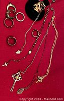 Multiple necklaces and ring bases displayed on red background