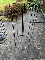 Large metal wire plant support ring showing circular top and vertical bars, open lattice design
