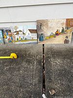 Five oil paintings on board outdoors against wall with measuring tape showing size range.