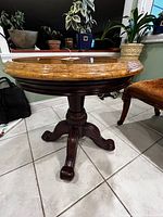 Full view of marble top side table showing round marble surface and dark wood pedestal base.