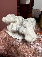 Front angle showing two reclining hippo forms on a marble table