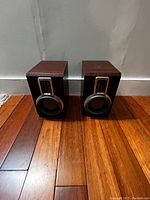 Front view of two Philips wooden speakers side by side on wooden floor
